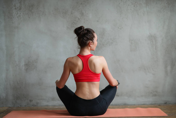 mooie jonge vrouw oefenen yoga thuis - Foto, afbeelding