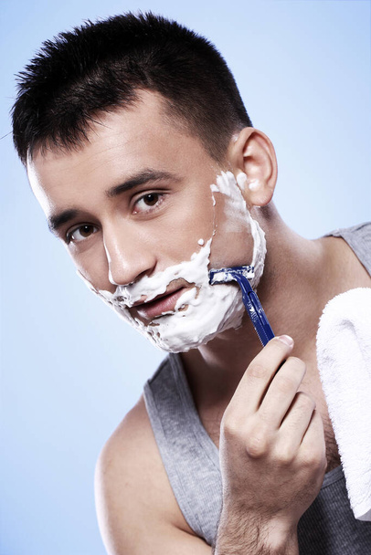 Portrait of handsome guy with shaving foam and razor - Foto, afbeelding