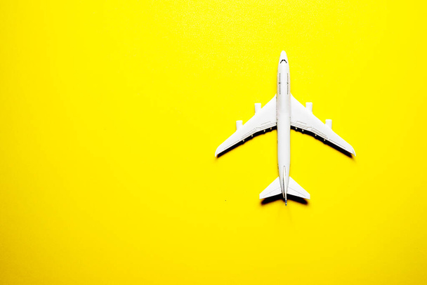 Miniaturowy samolot zabawkowy na żółtym tle. Wycieczka samolotem - Zdjęcie, obraz