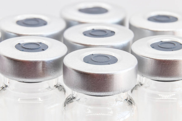 Fotografia macro de frascos de vidro para amostras líquidas e vacinas. concentre-se no primeiro frasco. Profundidade de campo rasa. - Foto, Imagem