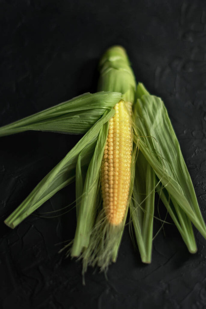 Fresh corn on the cob with seeds on a concrete background close up - 写真・画像