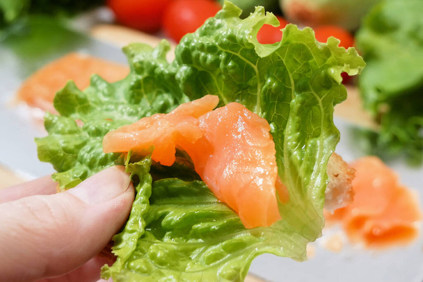 свіжа риба лосося з зеленим салатом та овочами, свіжий салат з зеленню, лососем та грінками
 - Фото, зображення
