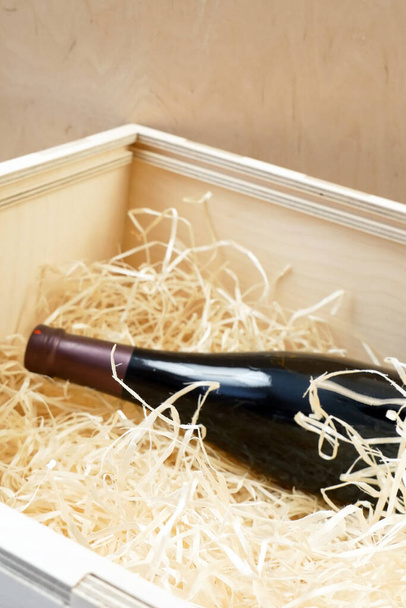 пляшки дорогого елітного вина в дерев'яній коробці з стружкою, онлайн замовлення і доставка вина в коронавірусний час, концепція інтернет-магазинів вина
 - Фото, зображення