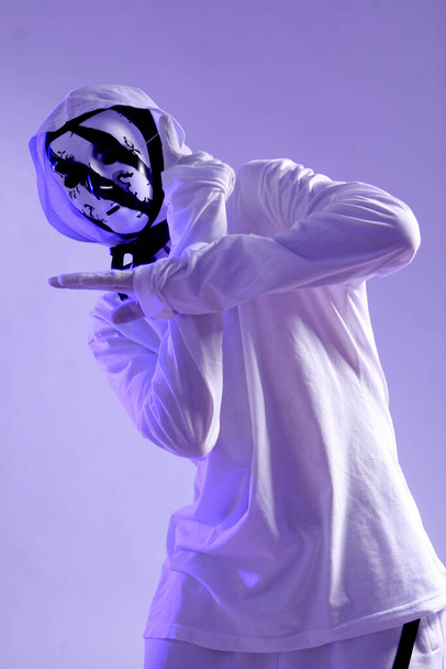 スタジオで踊る白い衣装を着たスタイリッシュなヒップホップダンサー - 写真・画像