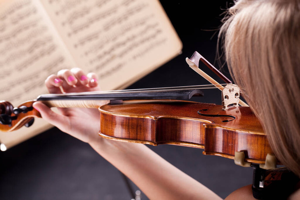 Woman with the violin over black background - Photo, Image