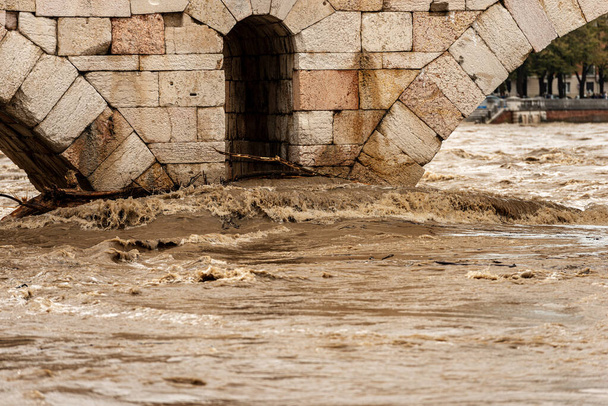Verona, Nahaufnahme der Ponte Pietra (Steinbrücke), I Jahrhundert v. Chr., und des Flusses Etsch, der nach mehreren heftigen Stürmen überschwemmt wurde. Venetien, Italien, Europa - Foto, Bild