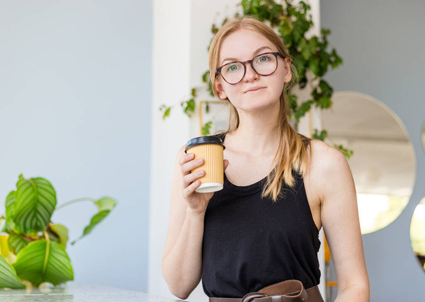 Schöne junge Hipster-Frau mit blonden Haaren ruhen und trinken Kaffee. Konzept zum Mitnehmen. - Foto, Bild