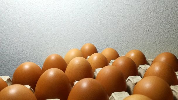 Huevos de pollo crudos y frescos que provienen de la granja de pollos se colocan en el recipiente. - Foto, Imagen