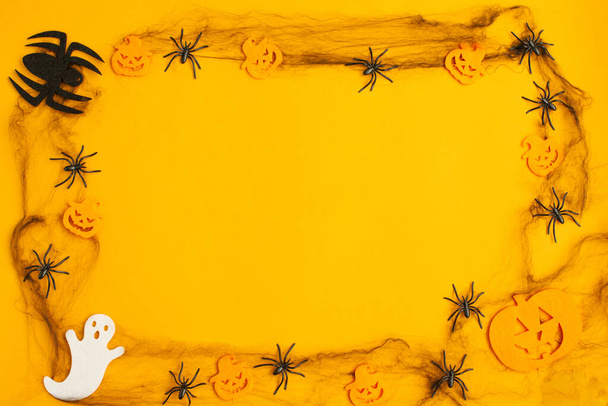 Halloween holiday with black spiders, web on orange background. Flat lay, top view. Space for text, mock up, seasonal minimal party concept. - Photo, Image