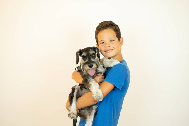 Handsome boy smiling with his dog in his arms - Photo, image