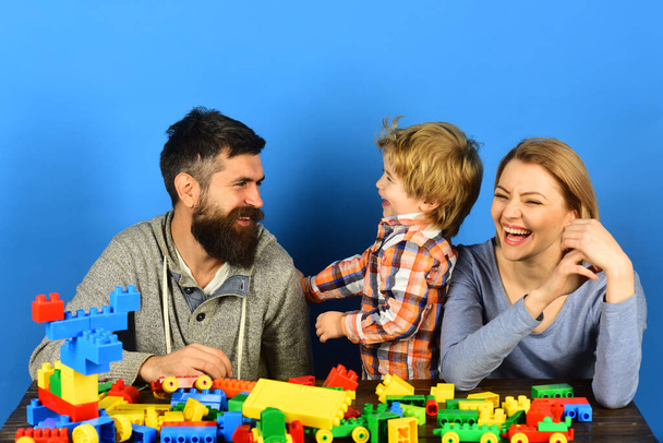 Family with happy faces communicate near colored construction blocks - Foto, Imagen