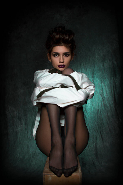 sexy girl with long legs in black tights and a white straitjacket. - Photo, Image