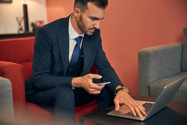 Homem confiante trabalhando no laptop na zona de business lounge - Foto, Imagem
