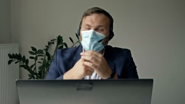 Work during the coronavirus epidemic. A middle-aged businessman with relief removes his medical mask at the end of the working day. - Video
