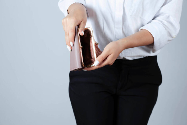 Woman holds an empty wallet in hands outdoor. Finance problem concept - Φωτογραφία, εικόνα