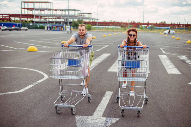 Supermarket trolley. A man and a woman are driving a supermarket trolley. - Foto, afbeelding