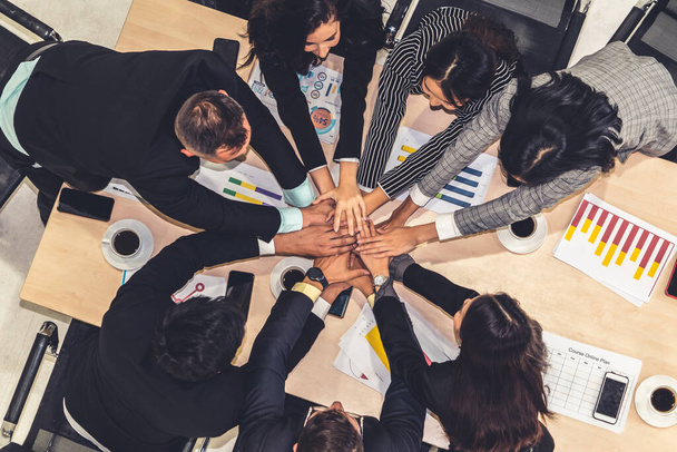 Happy business people celebrate teamwork success together with joy at office table shot from top view . Young businessman and businesswoman workers express cheerful victory showing unity and support . - Photo, Image