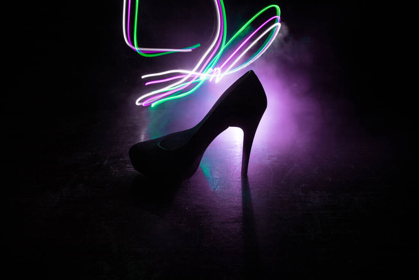 Decorazione d'arte. Silhouette di un tacco alto scarpe da donna al buio. Potere delle donne o concetto di dominazione delle donne. Focus selettivo - Foto, immagini