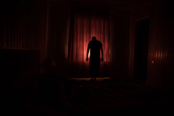 Horror silhouet in het raam met gordijn in de slaapkamer 's nachts. Een horrorscène. Halloween concept. wazig silhouet van geest - Foto, afbeelding