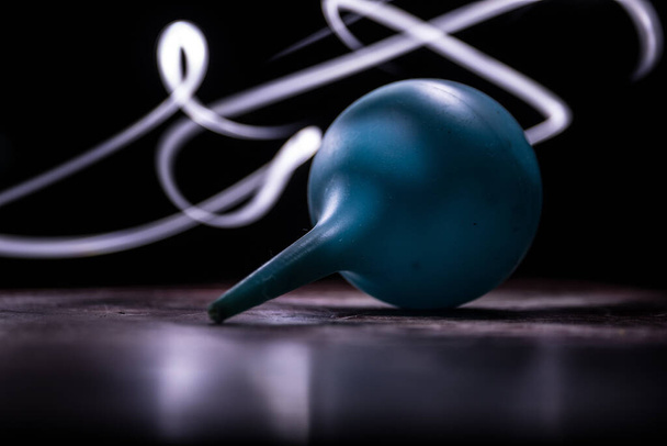 Blue enema on dark background with backlight. Creative artwork decorated with light. Selective focus - Fotó, kép