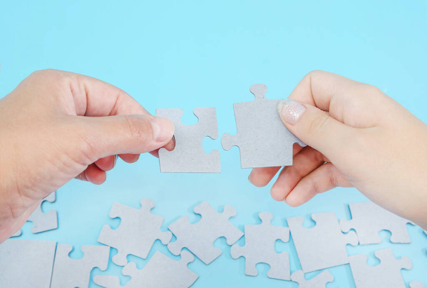 Dvě ruce spojující puzzle na modré. Detailní záběr. - Fotografie, Obrázek