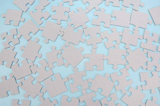 piezas de rompecabezas gris sobre un fondo azul. Fondo de rompecabezas - Foto, Imagen