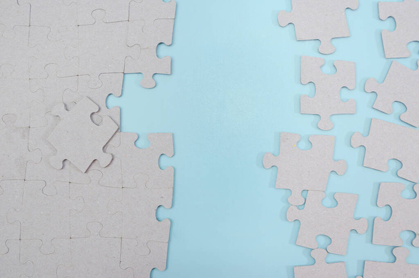 Pezzi di puzzle grigi incompiuti su uno sfondo blu. idea di business. - Foto, immagini
