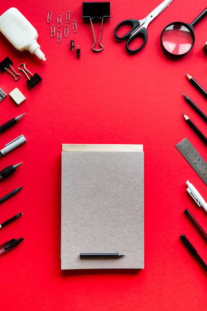 Długopisy i ołówki na czerwonym tle. Widok z góry z miejsca kopiowania - Zdjęcie, obraz