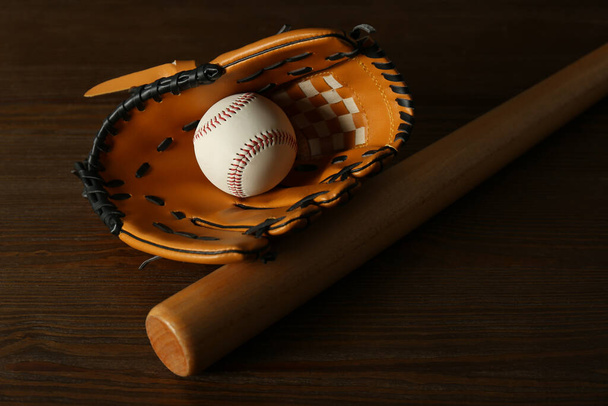 Leather baseball ball, bat and glove on wooden table - Фото, изображение