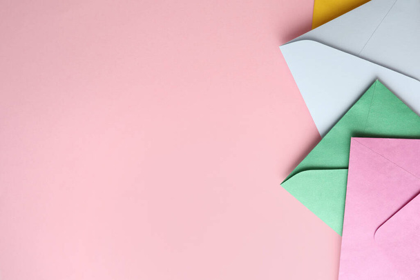 Colorful paper envelopes on pink background, flat lay. Space for text - Fotoğraf, Görsel