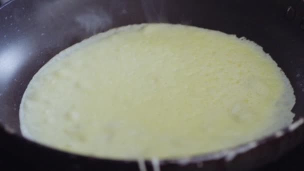 電気ストーブの上に古いフライパンでロシアのパンケーキを調理. - 映像、動画