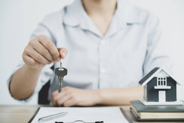 Passare un agente immobiliare, tenere le chiavi, e spiegare il contratto di lavoro, affitto, acquistare, mutuo, prestito, o assicurazione casa. - Foto, immagini