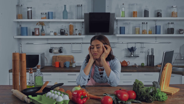 Κουρασμένη γυναίκα κοιτάζοντας πρώτες ύλες στο τραπέζι της κουζίνας  - Πλάνα, βίντεο