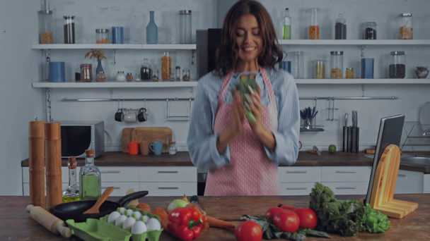 Femme debout près des légumes crus sur la table de cuisine  - Séquence, vidéo