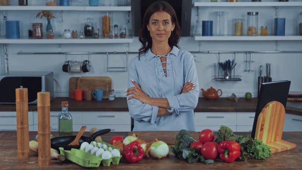 Donna che mostra gesto giusto vicino verdure crude sul tavolo della cucina  - Filmati, video