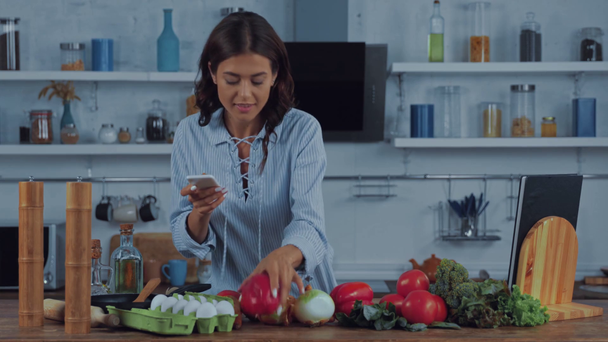 Γυναίκα φωτογράφηση και λήψη selfie με smartphone κοντά σε λαχανικά  - Πλάνα, βίντεο
