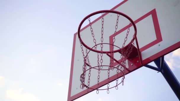 Kosárlabda karika az égen háttér. A labda belerepül a kosárlabdába, és nem üt. Lassú mozgás.. - Felvétel, videó