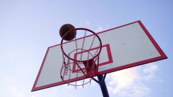 Basketball Hoop On The Sky Background (en inglés). Close-up of Ball Flies into Basketball Hoop (en inglés). Movimiento lento. - Imágenes, Vídeo