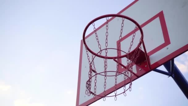 クローズアップ・バスケットボール・フープ。ボールはバスケットボールのフープに飛び込み、ヒットしない、スローモーション - 映像、動画