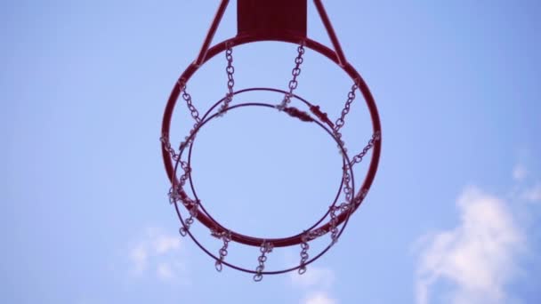 Een close-up van Basketball Hoop. Oranje bal vliegt in basketbal Hoop, slow motion - Video