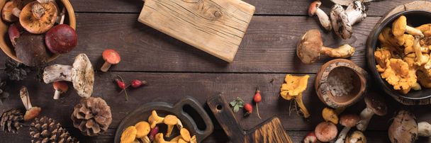 Autumn harvest of mushrooms on vintage rustic wooden background. Rustic kitchen table. Flat lay top, top view . Layout with free text space. - Photo, image