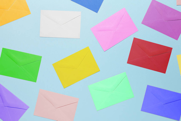 top view image of colorful envelopes on light blue surface, random pattern - Foto, afbeelding