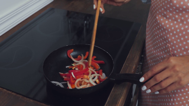 Vista cortada de mulher fritando legumes no fogão  - Filmagem, Vídeo