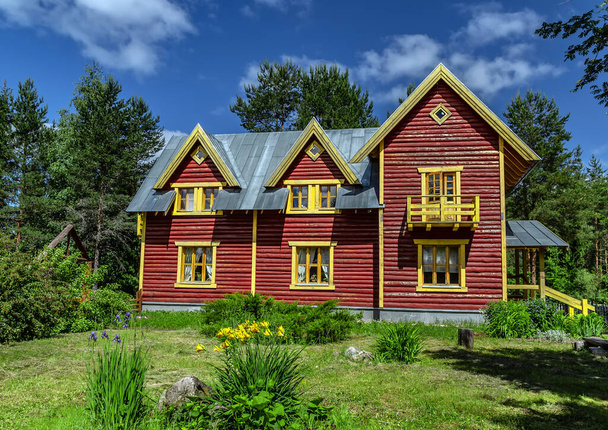 Casa de madera sobre hierba verde con cielo azul. - Foto, Imagen