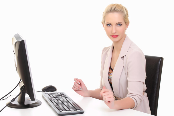 白い背景に対して隔離される彼女のオフィスの机でコンピューターに取り組んでいる女性実業家. - 写真・画像