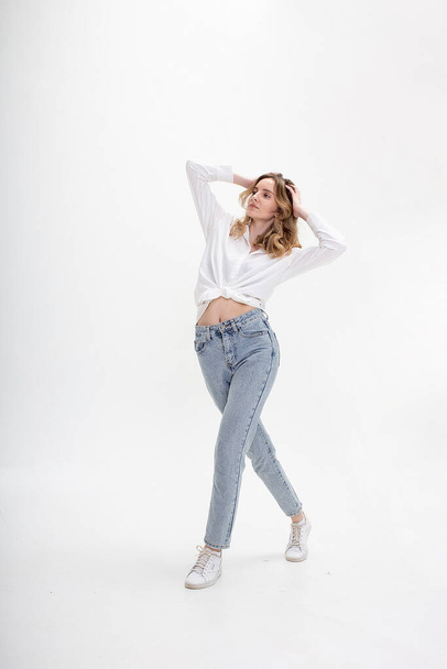 young caucasian girl in shirt, jeans, isolated on white background posing - Fotó, kép