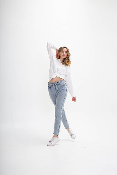 joven chica caucásica en camisa, jeans, aislado sobre fondo blanco posando - Foto, imagen