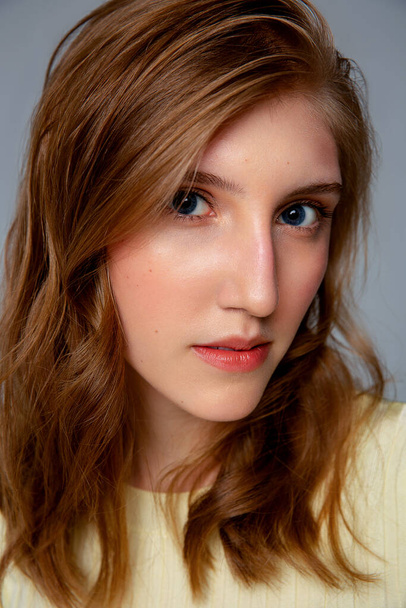 Retrato de cerca de una mujer joven con la piel perfecta limpia con un reflejo rojo en la cara - Foto, Imagen