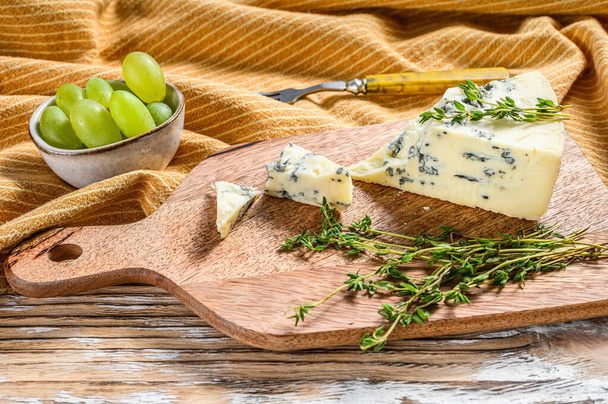 Francia Gorgonzola sajt szőlővel. Fehér fa háttér. Felülnézet. - Fotó, kép