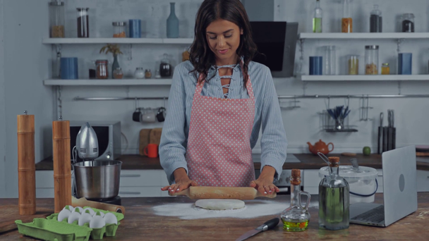 Γυναίκα που χρησιμοποιεί φορητό υπολογιστή ενώ κάνει ζύμη στην κουζίνα  - Πλάνα, βίντεο